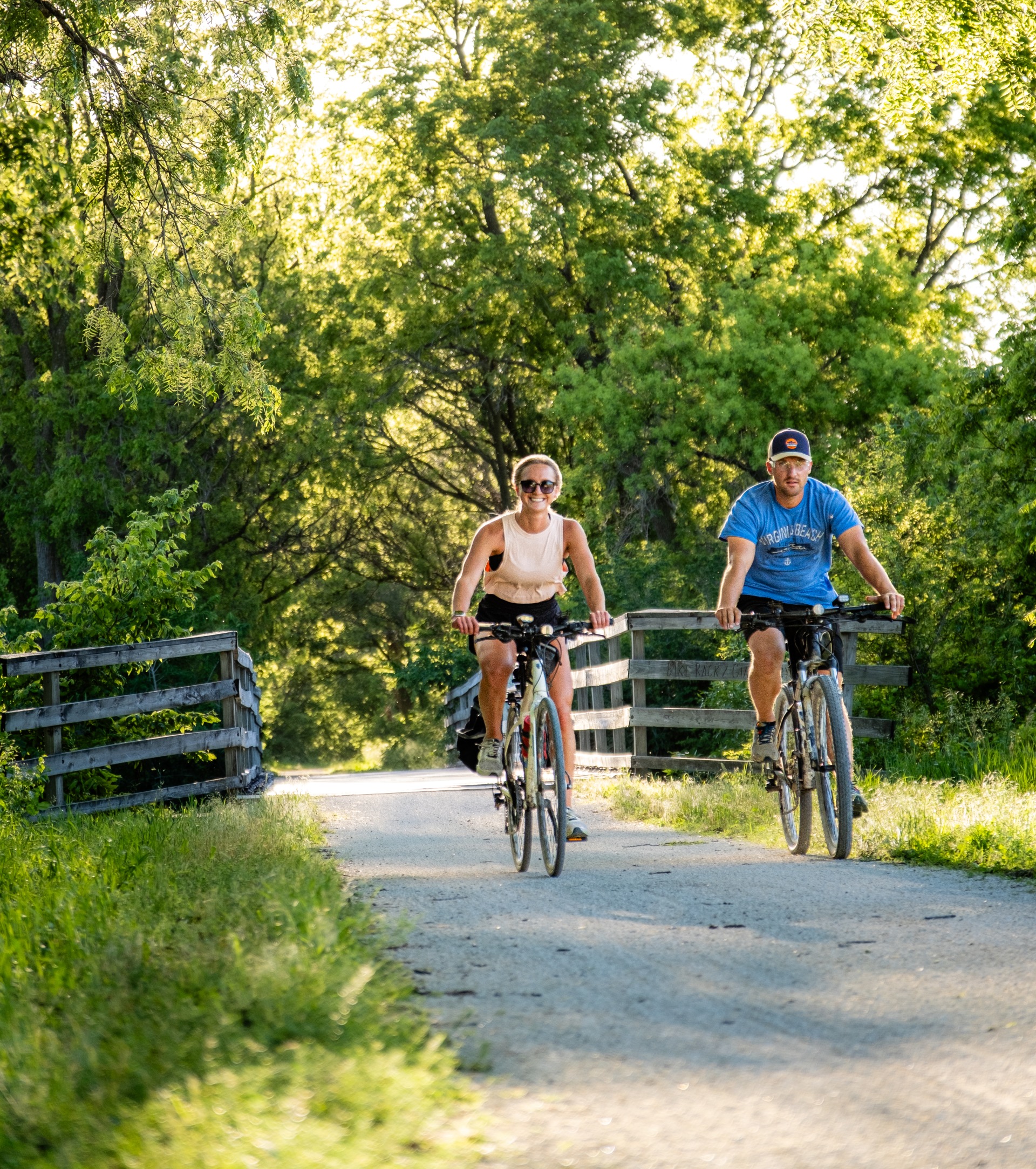 two cyclists smile as they ride along the Wabash Trace Nature Trail
