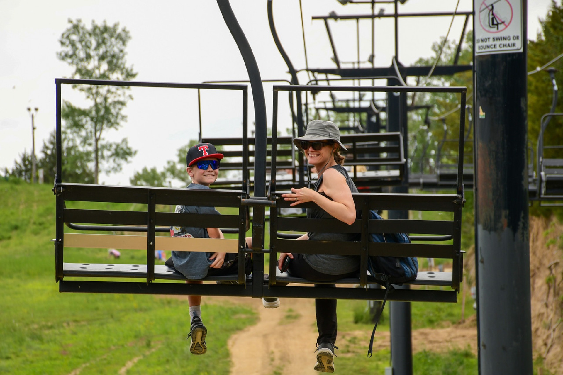 An child is accompanied by an adult on a scenic lift ride