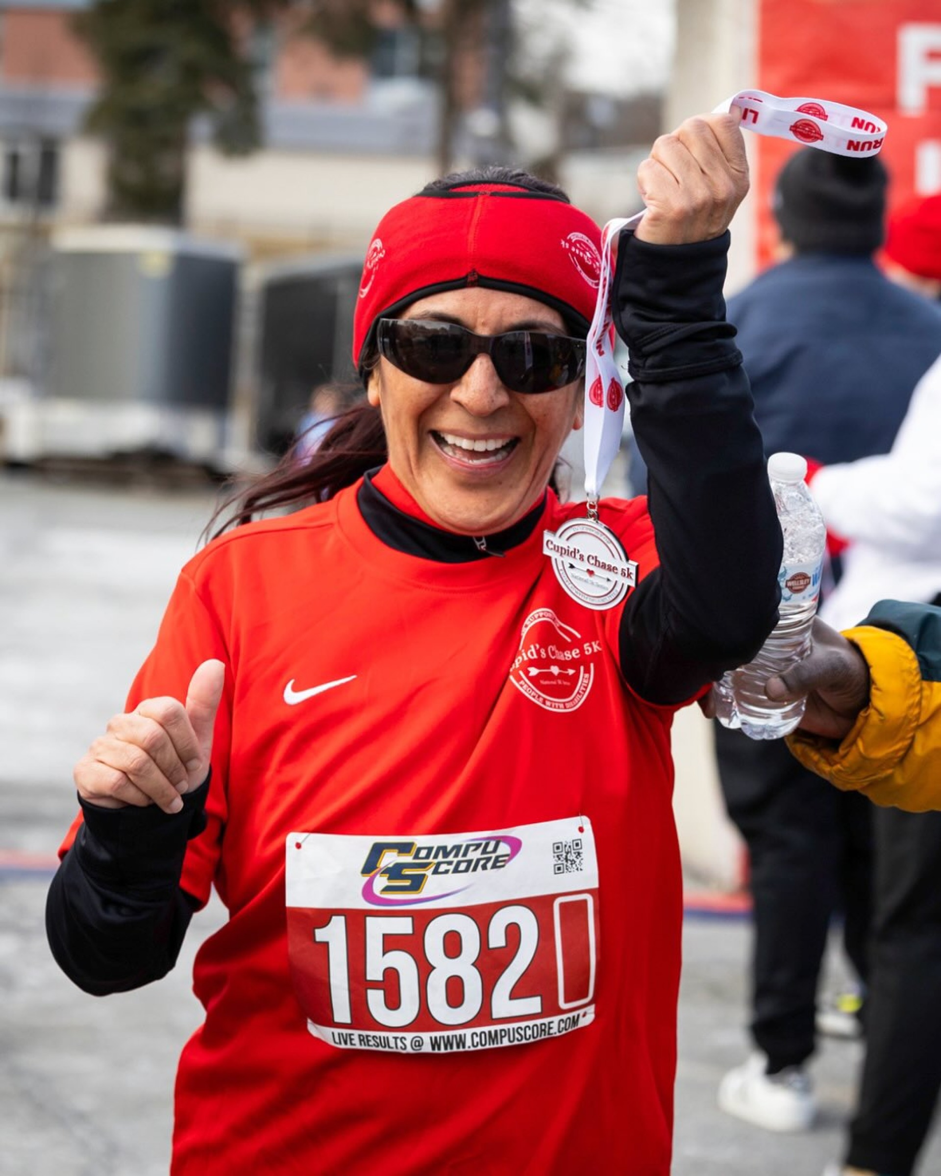 Woman holding a medal at the Cupids Chase