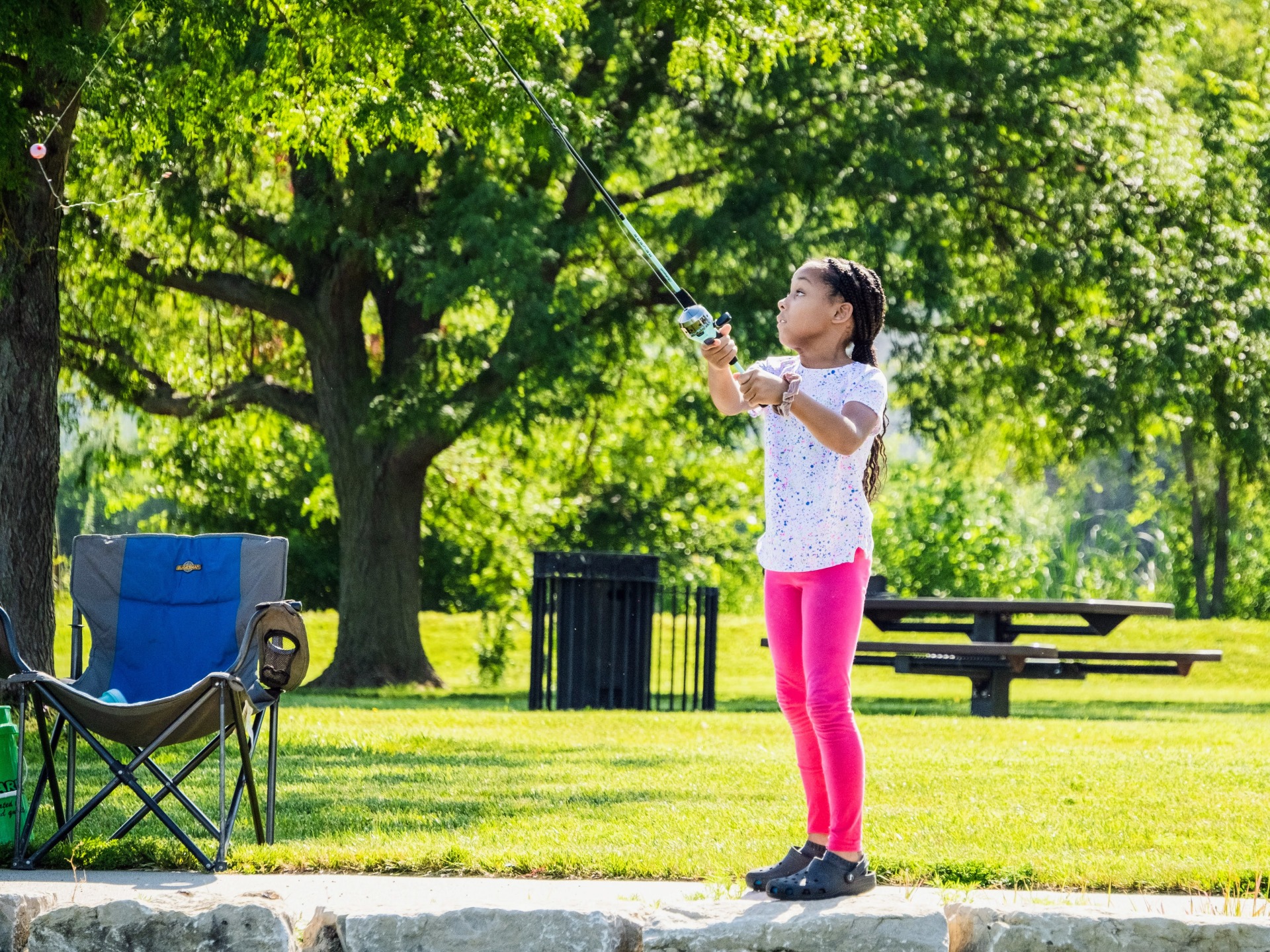 A child enjoys casting a fishing line into the water
