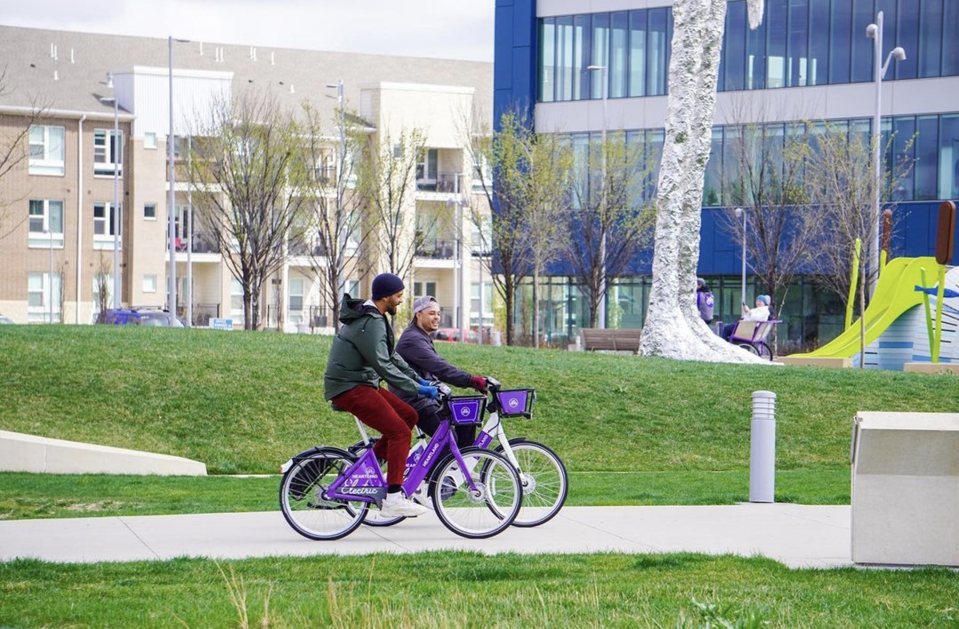 Two cyclists smile as they ride bikes on Iowa Riverfront Trail