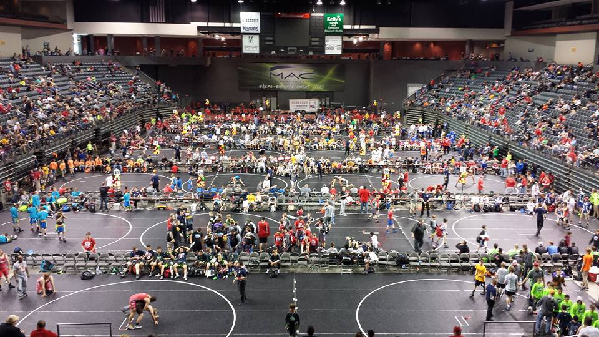 Wrestlers and spectators fill the floor and arena at Mid-America Center