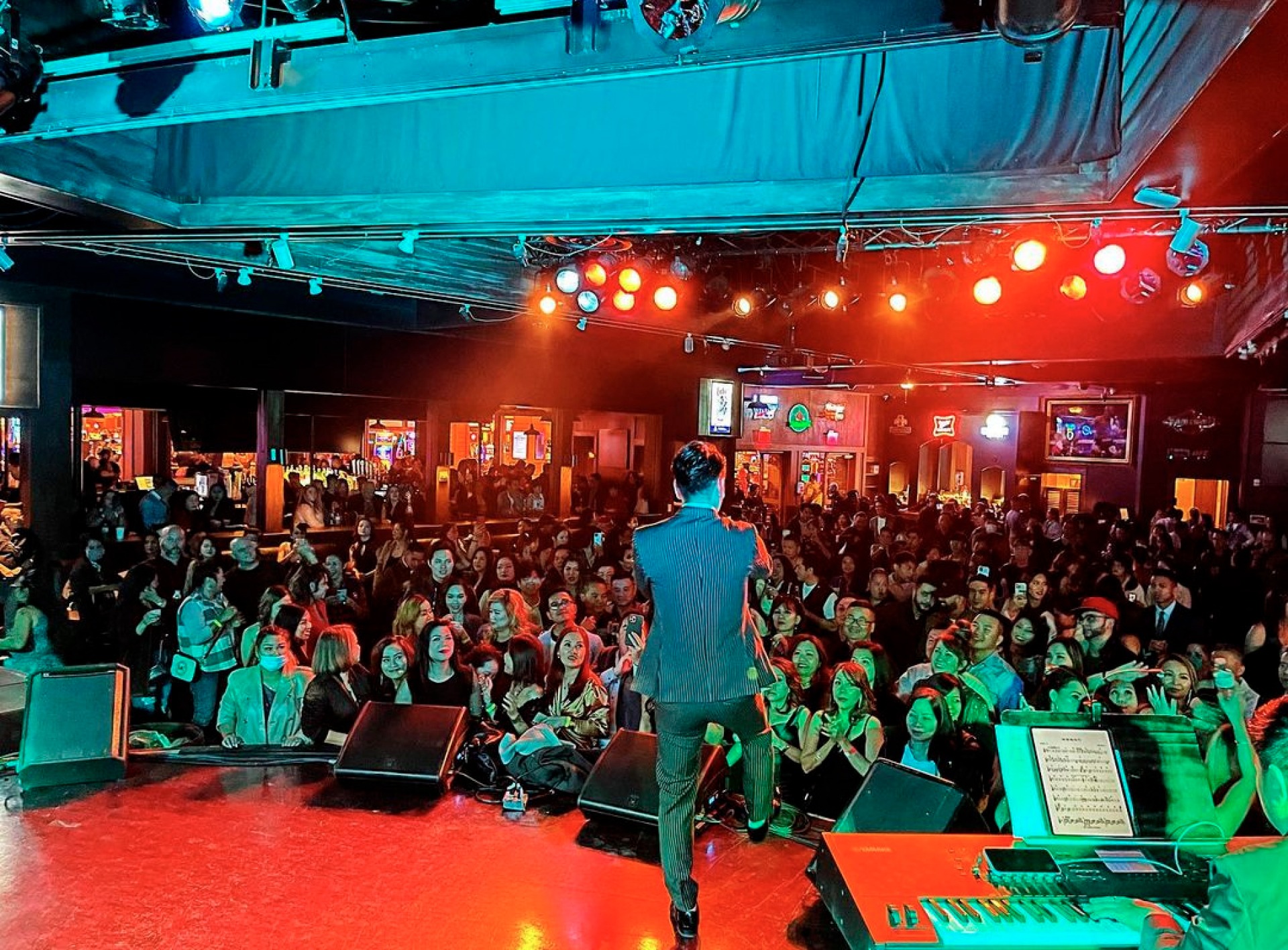 Man standing on stage looking over a crowd 