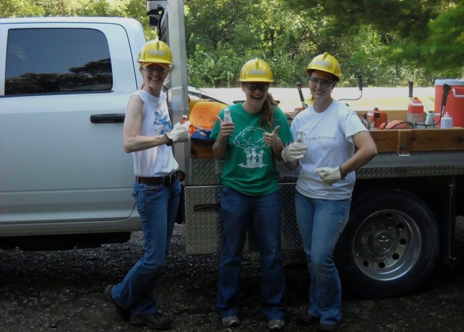 Kelly in a hard hat helping to cut trees.