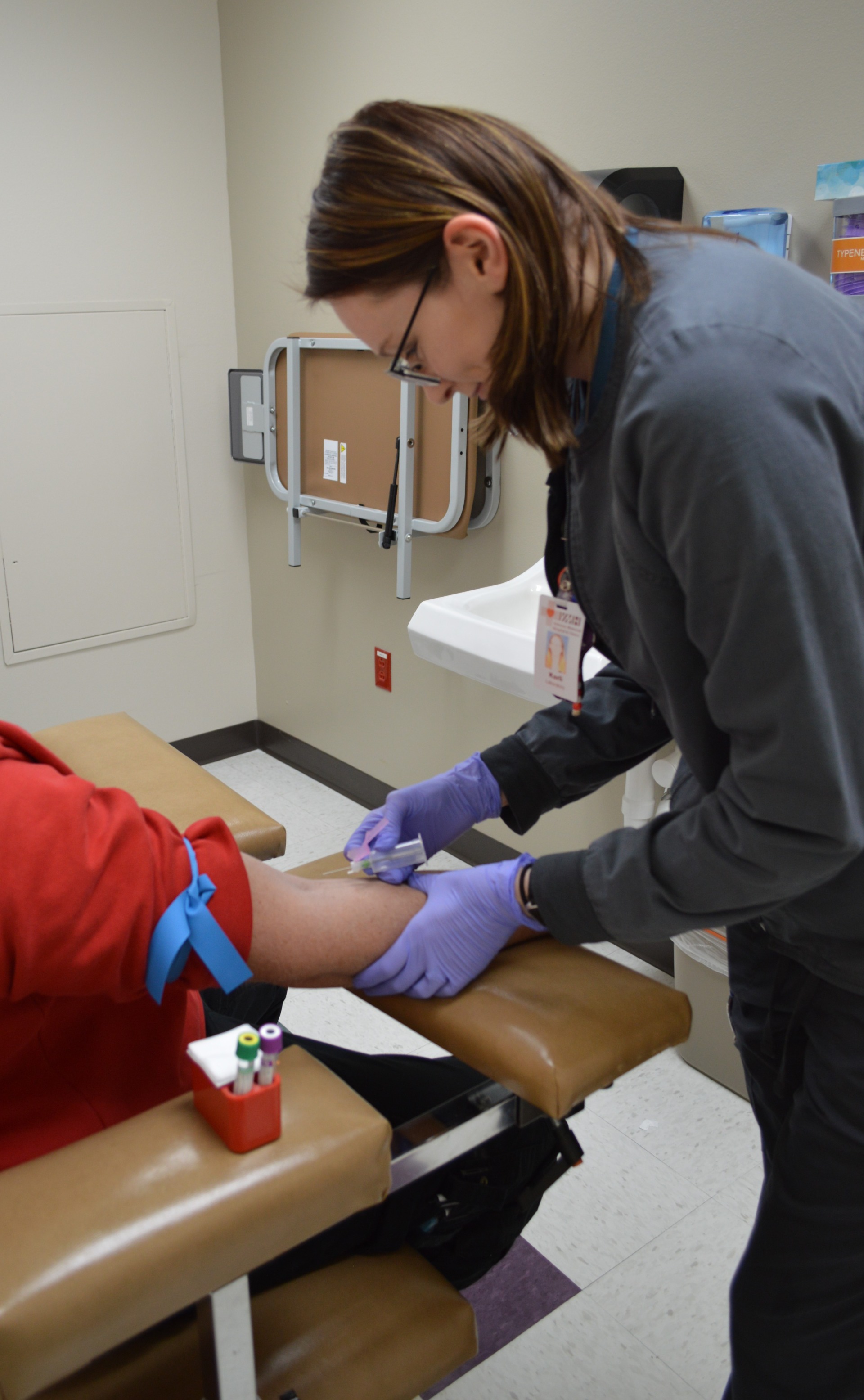 Karli Rains drawing blood from a patient.
